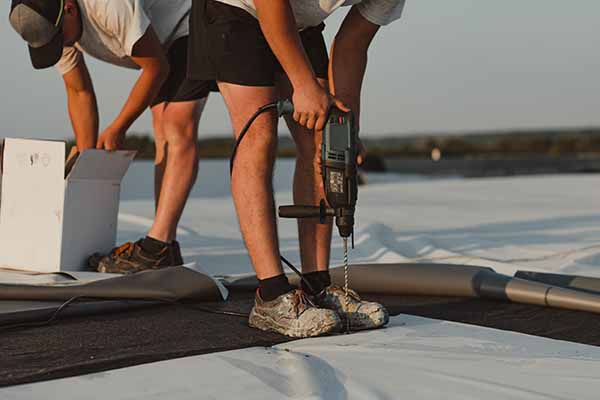 Two roofers installing a Commercial Roof